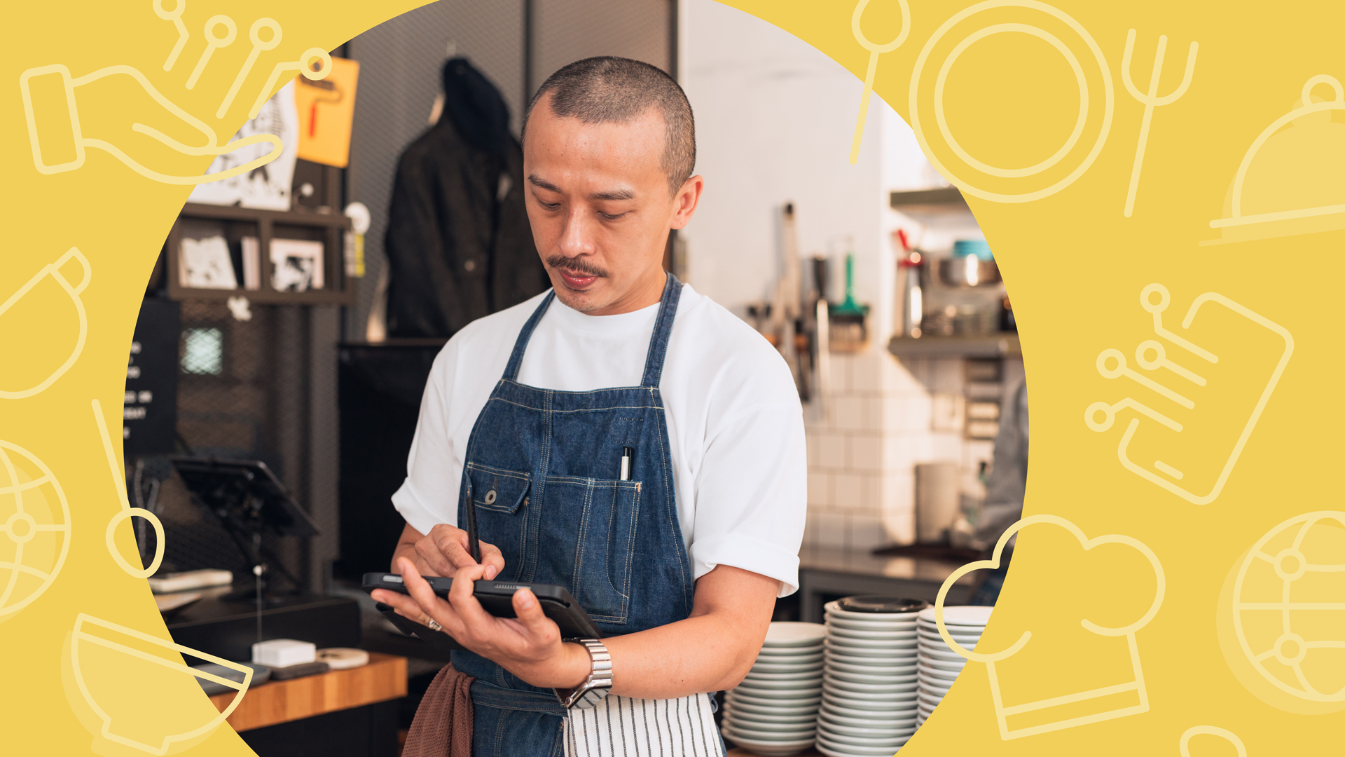 A chef wearing a denim apron uses a digital tablet inside a busy commercial kitchen, surrounded by plates and equipment, with a yellow hospitality-themed graphic overlay framing the scene.