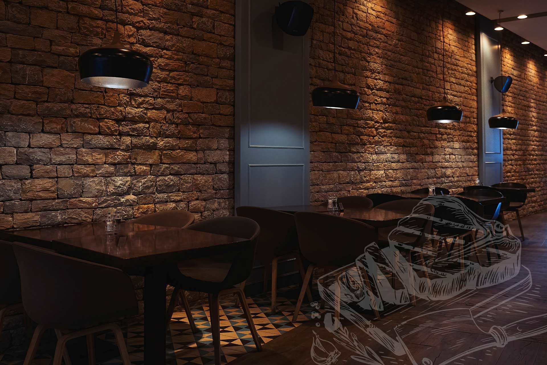 A dimly lit restaurant interior with exposed stone walls, pendant lights, dark timber tables, and contemporary chairs arranged in rows. A subtle illustrated overlay of a steak and carving fork appears in the lower right corner.