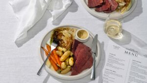A plate of corned silverside, boiled kipfler potaotes, baby