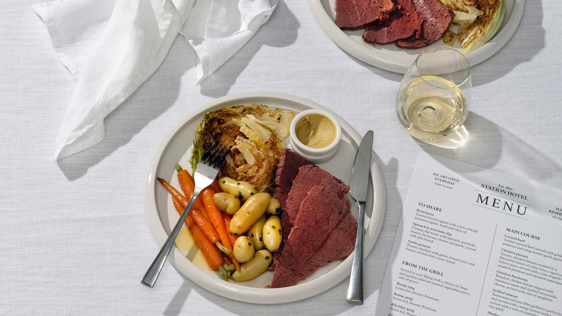 A plate of corned silverside, boiled kipfler potaotes, baby