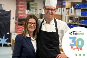 Donna Brown and Executive Chef Matthew Arnold smiling together in the Brisbane Convention & Exhibition Centre kitchens, celebrating Bidfood’s 30 years in Australian foodservice.