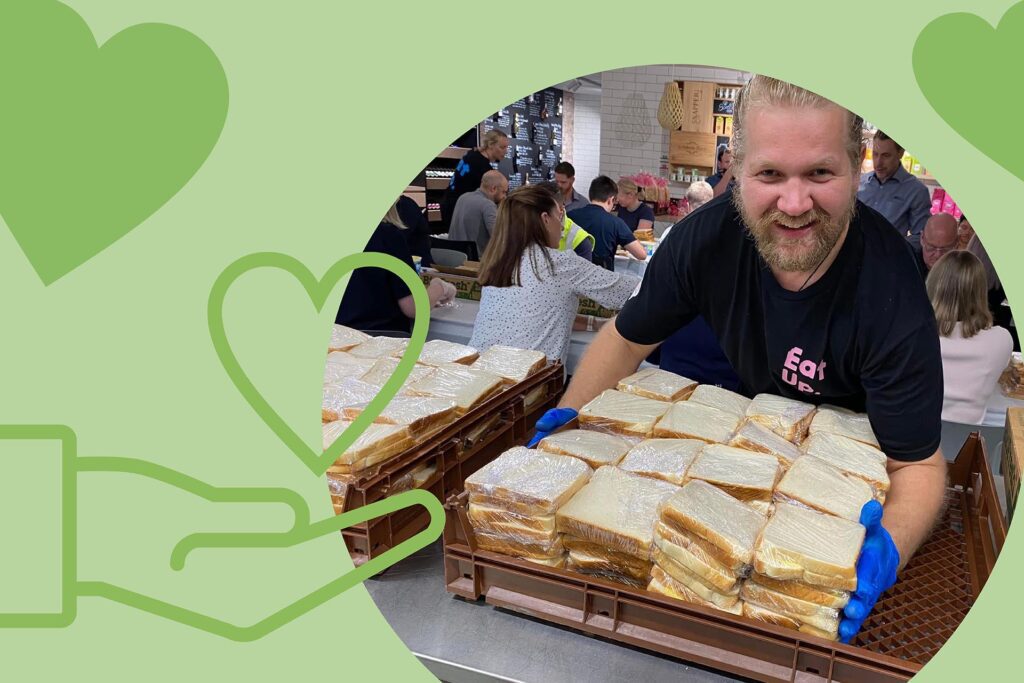 A group of people preparing sandwiches in a community kitchen setting, with trays of wrapped sandwiches in the foreground. The image is overlaid with green graphics and text that reads 'Aligning your CSR,' indicating a focus on corporate social responsibility activities." This image shows a community kitchen where people are preparing sandwiches. The trays of wrapped sandwiches in the foreground suggest a large-scale effort, likely for a charitable cause. The text "Aligning your CSR" highlights the relevance of corporate social responsibility, making this image interesting for businesses looking to engage in community service initiatives.